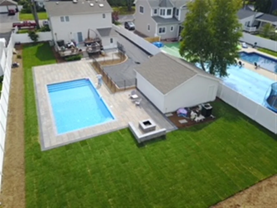 aerial shot of beautiful back yard with full pavers and inground pool