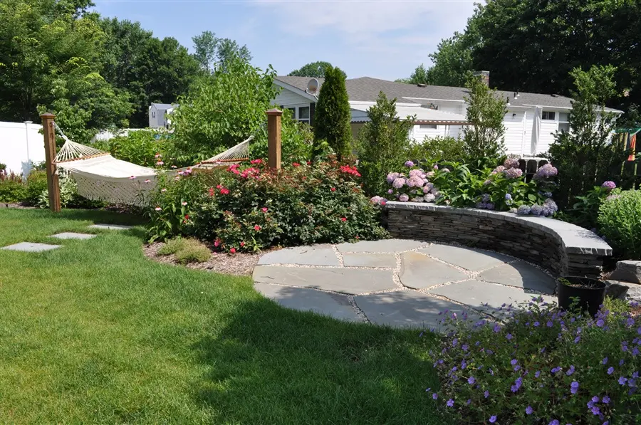 landscaped garden with trees and plants and a hammock